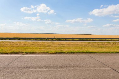 Yaz macera yol asfalt, altın çavdar alan, mavi bulutlu gökyüzü ile