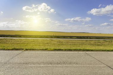Yaz macera yol asfalt, altın çavdar alan, mavi bulutlu gökyüzü ile