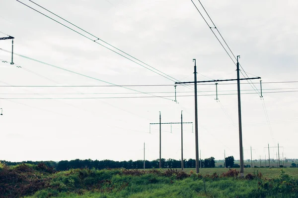 Líneas de alta tensión y torres eléctricas en un paisaje agrícola plano y verde en un día soleado —  Fotos de Stock