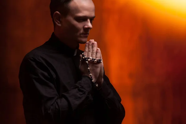 Retrato de sacerdote católico guapo o pastor con collar de perro, fondo rojo oscuro . —  Fotos de Stock