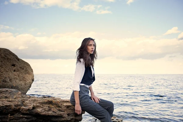 大きな石の上にコスト海近くスーツ ベストと白シャツに立ってビジネス女性 — ストック写真