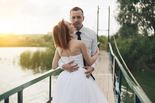 Νύφη και ο γαμπρός στέκεστε πάνω στην γέφυρα — Φωτογραφία Αρχείου