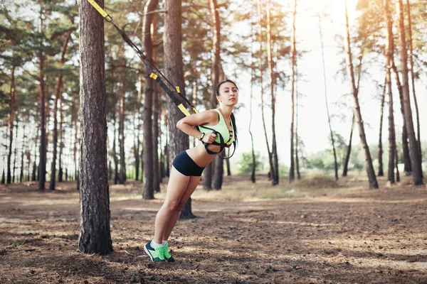 Beautiful young woman doing trx exercise with suspension trainer — Stock Photo, Image