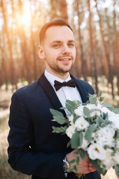 Porträt eines Mannes im Anzug mit einem Blumenstrauß in der Hand — Stockfoto