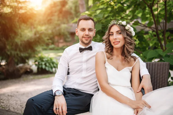 Braut und Bräutigam sitzen auf einem Stuhl — Stockfoto