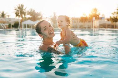 Holding alt tropikal yaz Yüzme Havuzu arka plan, anne