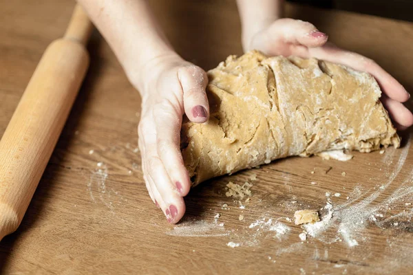 Hände rollen Teig für Lebkuchen auf den Holztisch — Stockfoto