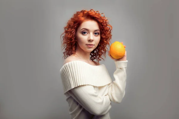Bella rossa riccia donna mangiare arancione — Foto Stock