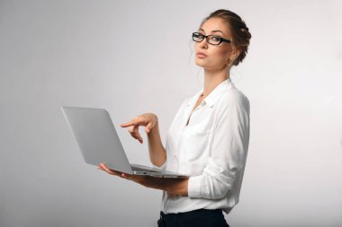 güzel kız beyaz ofis gömlekli dizüstü bilgisayar ekranında gösterir