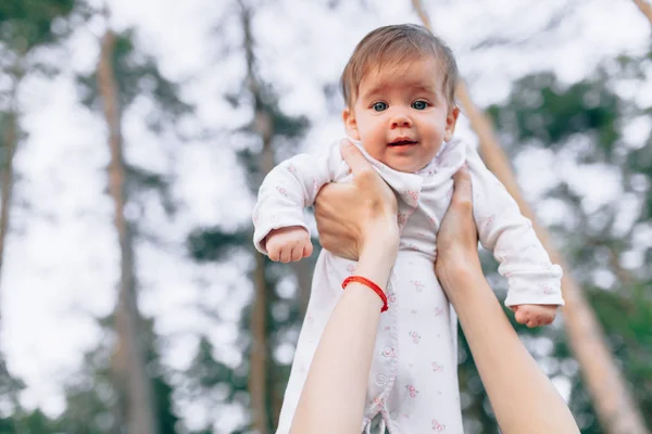 Mother hands tossing up the high air joyful baby. Outdoors healthy child activity, active lifestyle and having fun on family summer vacation — Stock Photo, Image