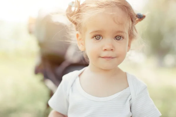 Babymeisje permanent in de buurt van een kinderwagen — Stockfoto