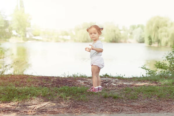 Meisje lopen en spelen buiten nabij lake — Stockfoto