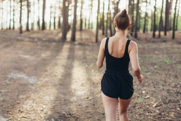 Healthy lifestyle brunet fitness sporty woman runner running in pine morning forest — Stock Photo, Image