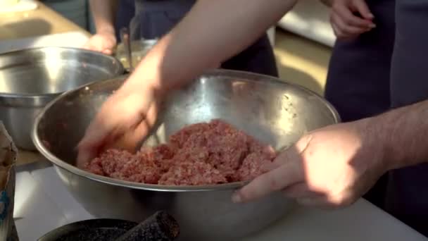 El cocinero en el delantal gris corta la carne en la tabla plástica. Foto de primer plano del proceso culinario — Vídeos de Stock