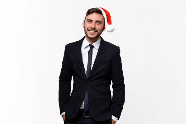 Jovem cara caucasiano bonito em terno de negócios e chapéus de Papai Noel fica no fundo branco no estúdio e dentes smilie — Fotografia de Stock