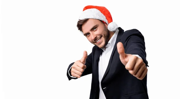 Junge hübsche kaukasische Kerl in Business-Anzug und Weihnachtsmann Hüte steht auf weißem Hintergrund im Studio smilie und zeigt Daumen nach oben. — Stockfoto