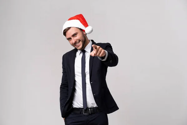 Jovem cara caucasiano bonito em terno de negócios e chapéus de Papai Noel fica no fundo branco em estúdio smilie e mostrando Dedo para a câmera . — Fotografia de Stock