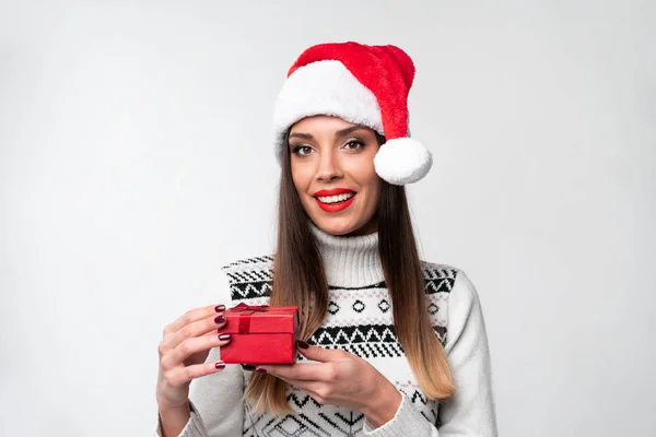 흰색 스튜디오 배경에 붉은 산타 모자를 쓰고 있는 아름다운 백인 여성의 초상화를 가까이 서 본 것입니다. 크리스마스와 연휴 개념. — 스톡 사진