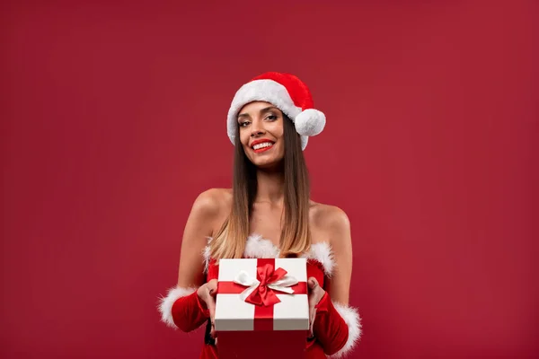 Close up retrato beautifiul mulher caucasiana em chapéu vermelho de Papai Noel no fundo estúdio vermelho. Conceito de Natal e Ano Novo . — Fotografia de Stock