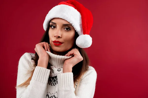 Közelkép portré gyönyörű kaukázusi nő piros Mikulás kalap piros stúdió háttér. Karácsony és újév ünnep koncepció. — Stock Fotó