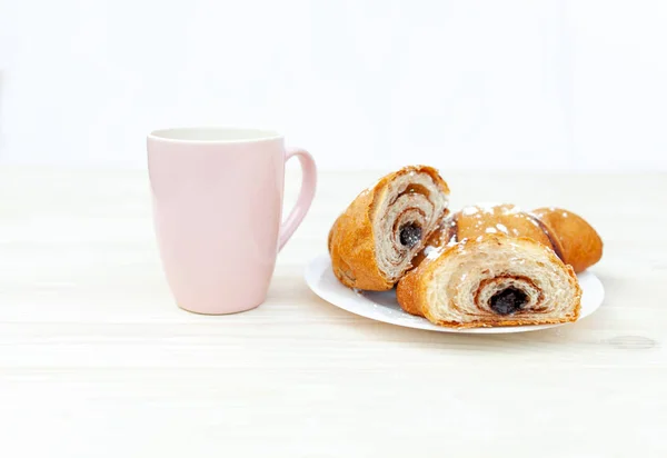 Croissant fresco com chocolate no fundo de madeira branca — Fotografia de Stock