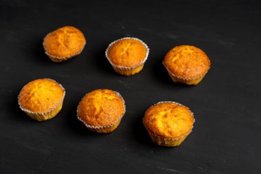 Iştah açıcı muffins bir masa üstü görünümünde duruyor. Koyu bir arka plan minimalizm geleneksel hamur işleri.