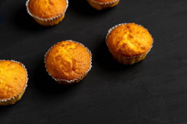Iştah açıcı muffins bir masa üstü görünümünde duruyor. Koyu bir arka plan minimalizm geleneksel hamur işleri.