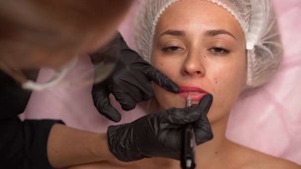 Arts cosmetoloog doet procedure permanente make-up vrouwelijke cliënt lippen 4k — Stockvideo