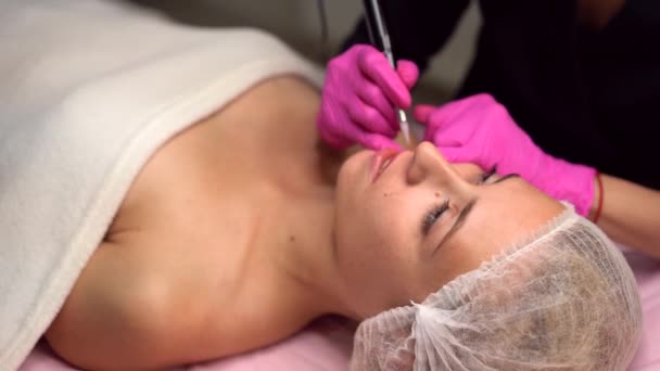 Doktor kosmetolog dělá stálý make-up ženský klientský rty 4k 