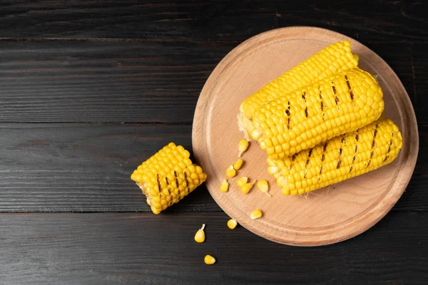 Grilled hot Corn cob lies on cutting board wooden table background. — Stock Photo, Image