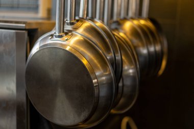 Mutfakta bir yığın profesyonel metal tava asılı. 