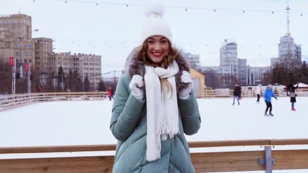 Όμορφη όμορφη μεσήλικη κοπέλα με σγουρά μαλλιά ζεστά μπουφάν χειμώνα στέκεται πάγο παγοδρόμιο φόντο Town Square. — Αρχείο Βίντεο