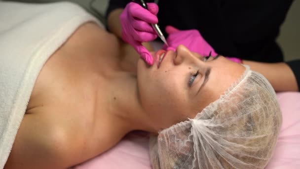 医師の美容師は、手順永久的なメイクアップ女性クライアント唇4kを行います — ストック動画