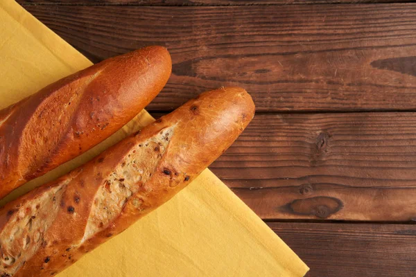 Duas baguetes francesas crocantes jazem em uma mesa de madeira velha com espaço livre para texto — Fotografia de Stock