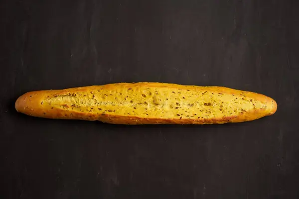 One crispy french baguettes lie on an old wooden table with free space for text — Stok fotoğraf