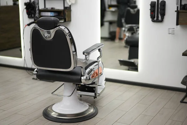 Classic vintage barber chair stands opposite mirror stylish white barber shop interior. — Stockfoto