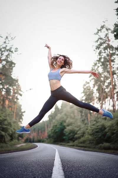 Young Beautiful Brunette Girl Jumping Twine Background Asphalt Road Pine — Stock Photo, Image