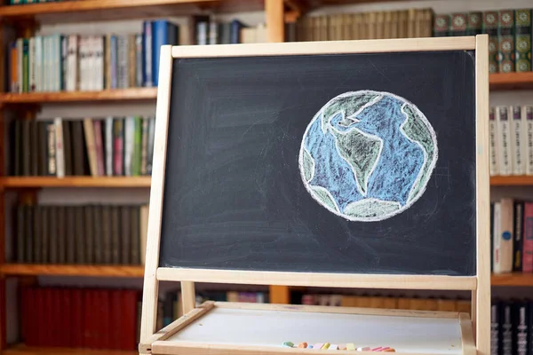 Chalk drawing on School blackboard planet Earth Earth oceans. Concept. Save the Earth Ecology problems. Virus epidemic coronavirus