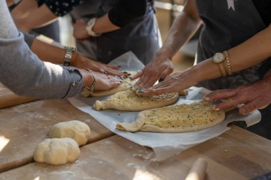 Mutfak ustası sınıfı. Khachapuri 'yi hazırlayan insanlara yakın çekim. Geleneksel Gürcü peynirli ekmek. Gürcü yemeği. Büyük, tanınmayan aile aşçı elleri.