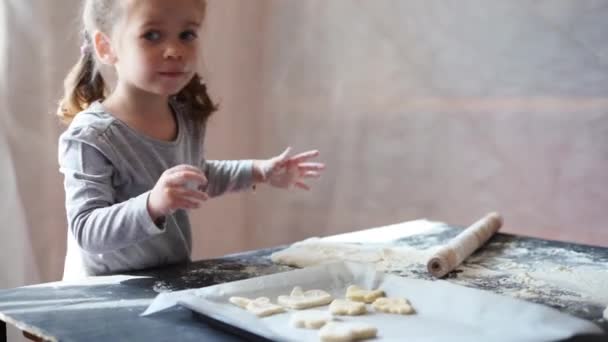 Roztomilý malý kavkazský dívka 3 roky připravuje cookies ze syrového těsta doma. — Stock video