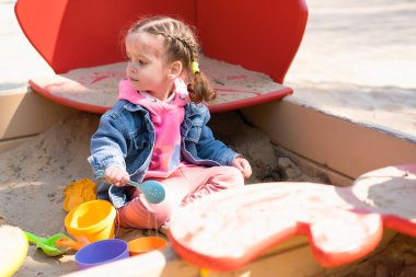 Oyun parkında sevimli beyaz bir kız, dışarıda zaman geçirmekten zevk alan mutlu bir çocuk, kaygısız bir çocukluk dönemi.