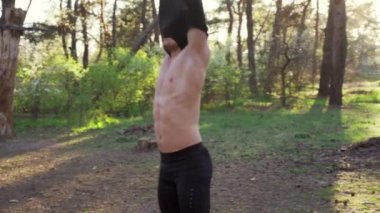 Atletik adam dışarıda spor yapıyor. Yakışıklı beyaz adam halk spor salonunu çapraz eğitiyor..