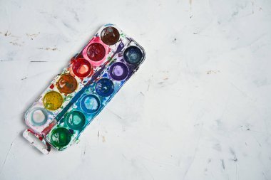 Suluboya seti beyaz arkaplanı boyar. Fırça çizimi. Yaratıcı bir geçmiş. Çizim öğretmenliği okulu. Metin için kopyalama alanı ile