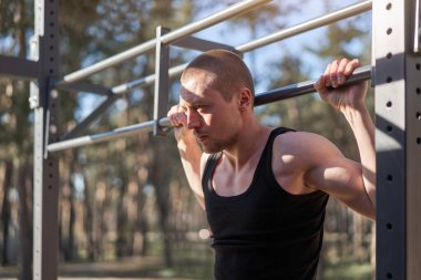 Yakışıklı beyaz erkekler sabah antrenman yapıyor. Spor sahası ormanı egzersizi yapıyor. Sağlıklı yaşam tarzı. Genç yetişkin erkek.