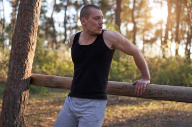 Yakışıklı beyaz erkekler sabah antrenman yapmak için havalanıyorlar. Kol pompalıyorlar. Spor sahası ormanı egzersizleri yapıyorlar. 