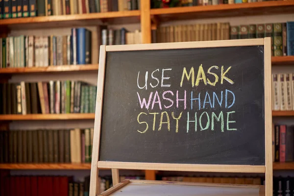 Use mask wash your hand Stay home Outbreak Warning. written white chalk on blackboard in connection with epidemic of coronavirus worldwide. Covid 19 pandemic Text on black background with free space.