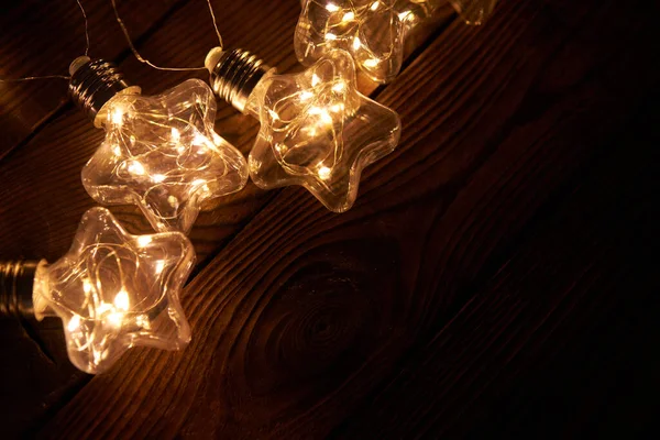 Brillantes Guirnaldas Navidad Luminosas Forma Estrellas Encuentran Sobre Fondo Madera — Foto de Stock