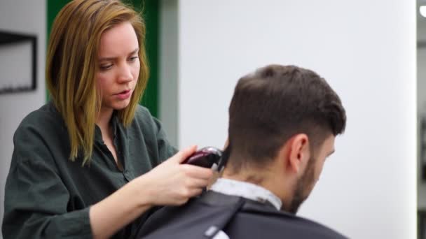 Schöner blauäugiger Mann im Friseursalon. Friseur Friseur Frau schneidet seine Haare. Friseurinnen. — Stockvideo