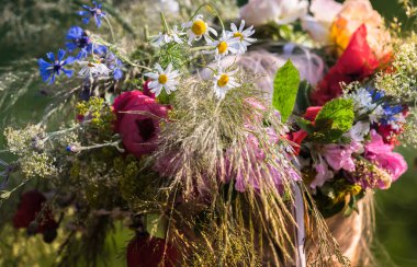 Başında yaz gündönümü çelengi, el yapımı, odak noktasında bireysel parçalar, yaz günü