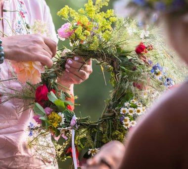 Başında yaz gündönümü çelengi, el yapımı, odak noktasında bireysel parçalar, yaz günü